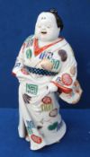 A Japanese porcelain model of a dignitary, holding a fan, 27cm high