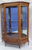 A large Edwardian mahogany display cabinet, the bowed top above a central glazed door and domed
