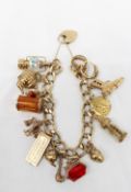 A 9ct yellow gold charm bracelet set with numerous charms including a lantern, teapot, leaf,