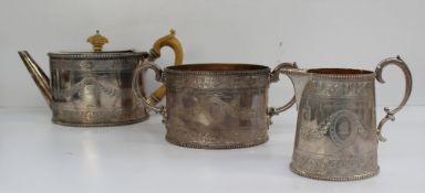 A Victorian three piece silver tea set of oval form with bright cut decoration of swags and leaves