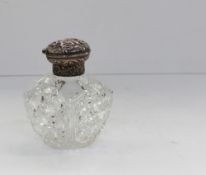 A late Victorian silver topped scent bottle decorated with figures, flower heads and scrolls,