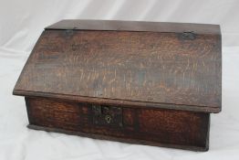 An 18th century oak bible box, the sloping fall enclosing a vacant interior on a plinth base, 61cm
