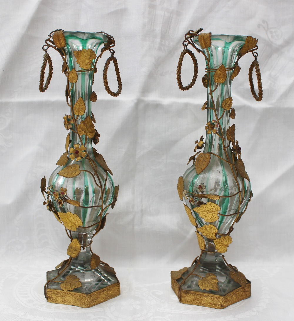 A pair of green and clear panelled glass vases with gilt metal mountings of leaves and flower heads,