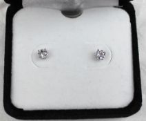 A pair of solitaire Diamond earrings, approximately 0.25 of a carat each, together with a card