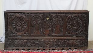 An 18th century continental oak coffer, the rectangular moulded top above a carved hinged front