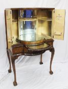 A 20th century walnut cocktail cabinet, the domed top above a rotating central section and two