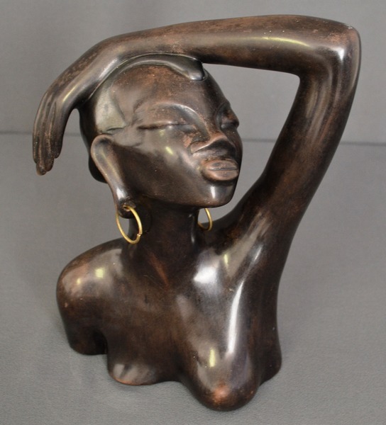 AN AUSTRIAN 1950?s ANZENGRUBER BUST of an African woman wearing brass earrings, base signed and
