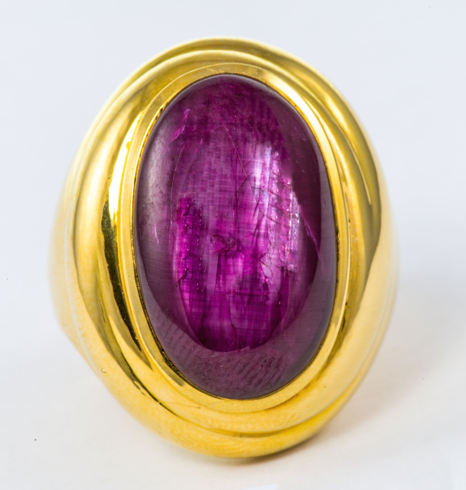 DE VROOMEN - an 18ct gold ruby ring, the oval ruby cabochon estimated to weigh 18.0ct, to the