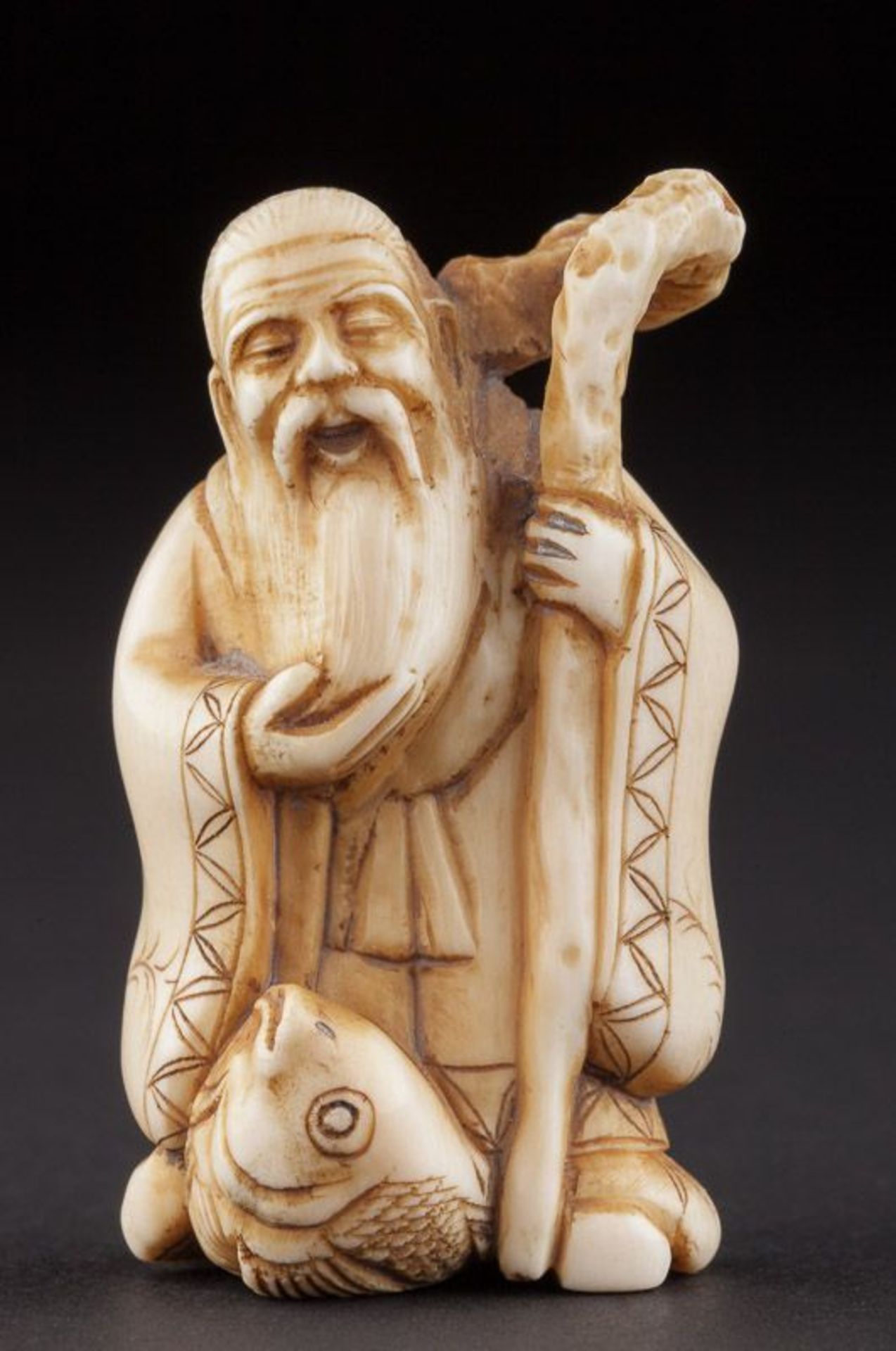 Netsuke um 1900 - Erotica netsuke  Elfenbein, Mönch mit Fisch und Wanderstab,   unterm Stand