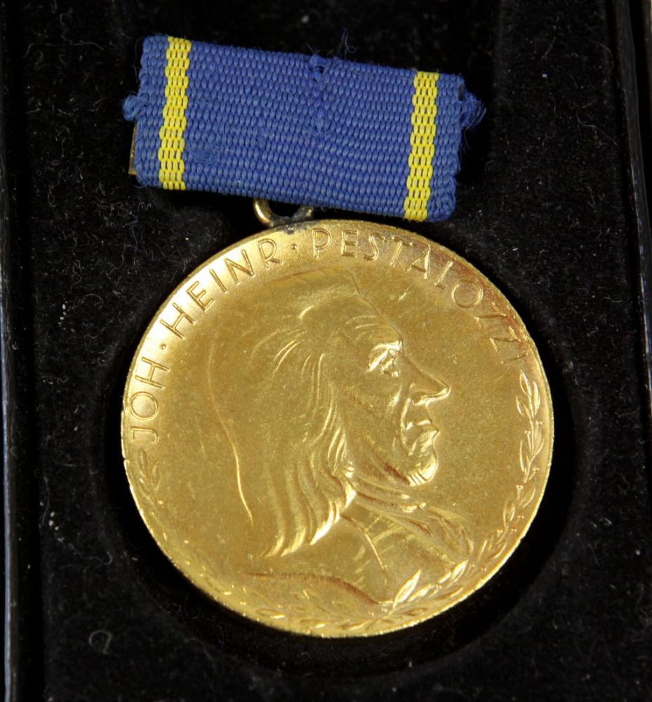 Pestalozzi Medaille für treue Dienste  goldfarbene Medaille in runder reliefierter Form, Brustbild