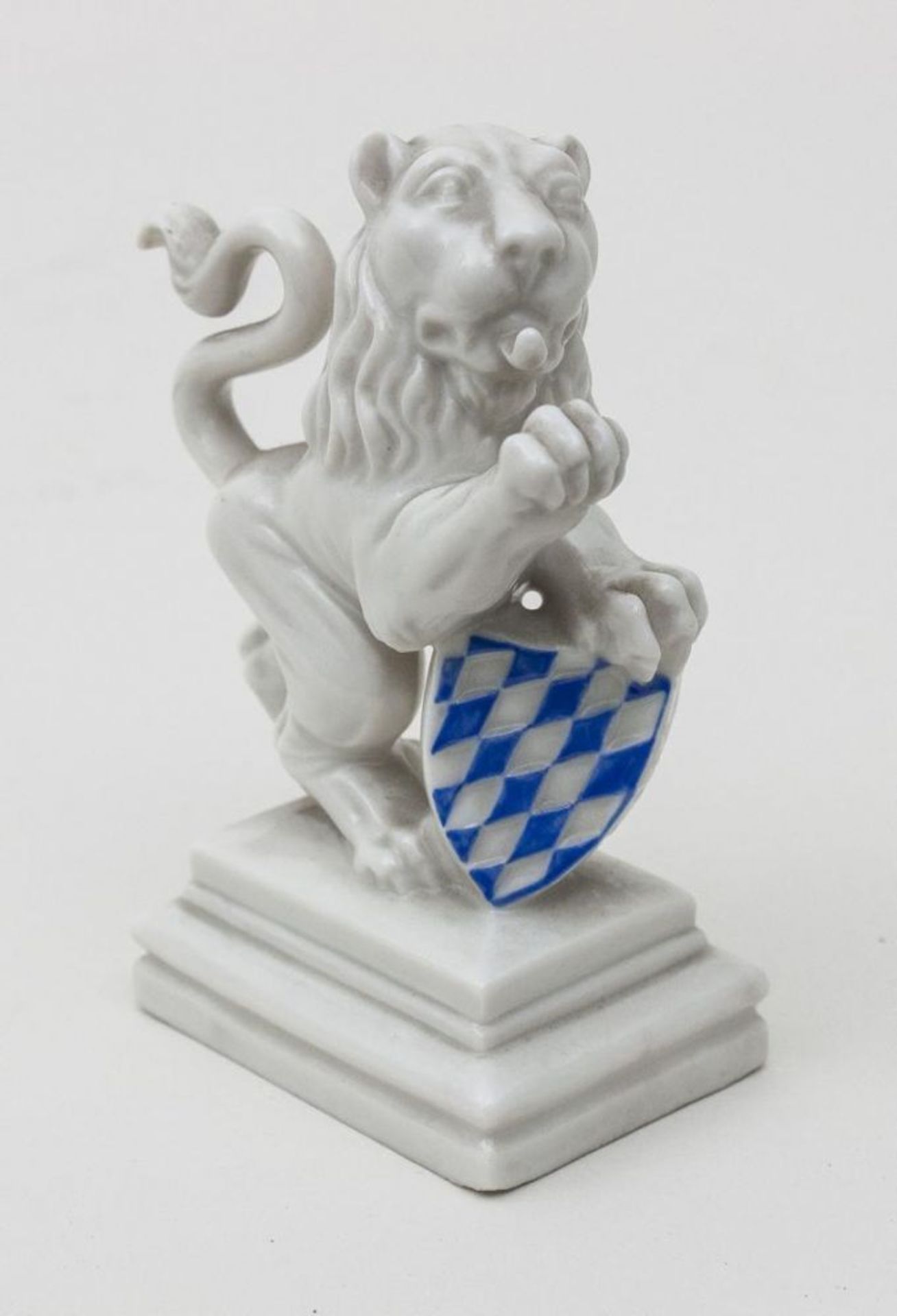 Löwe mit dunkelblauem Wappenschild, Nymphenburg, um 1900  auf rechteckigem getrepptem Sockel