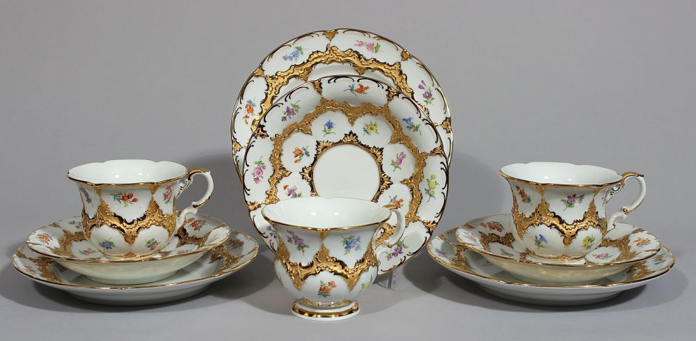 Drei Prunkgedecke, Meissen,  "B-Form". Bunte Streublümchenmalerei mit Goldbronzeornamenten und