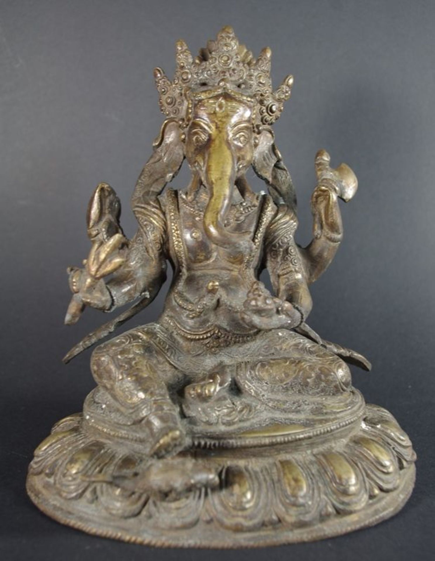 Sitzender Ganesha a. Lotossockel, am re. Fuß die Ratte sitzend, in den Händen Attribute haltend,