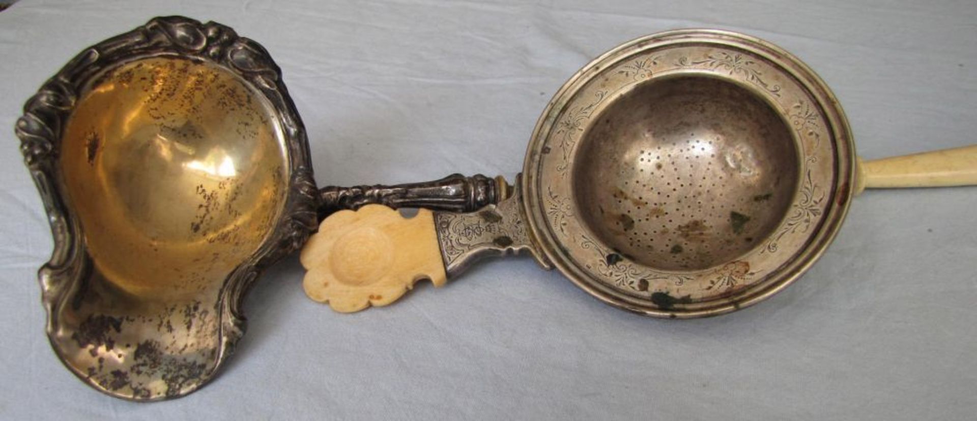 Ladle and strainer probably silver, with bone handles. 238 grams gross.  43 cm long. No Hallmarks