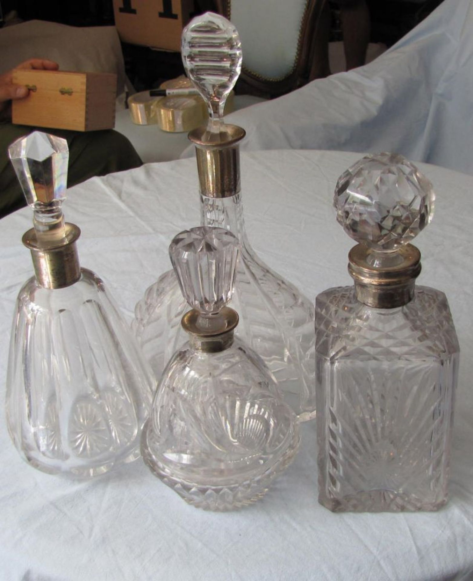 Four decanters, 835 and 925 silver mounts.  Up to 33 cm high.    Reserve price: 100    Vier