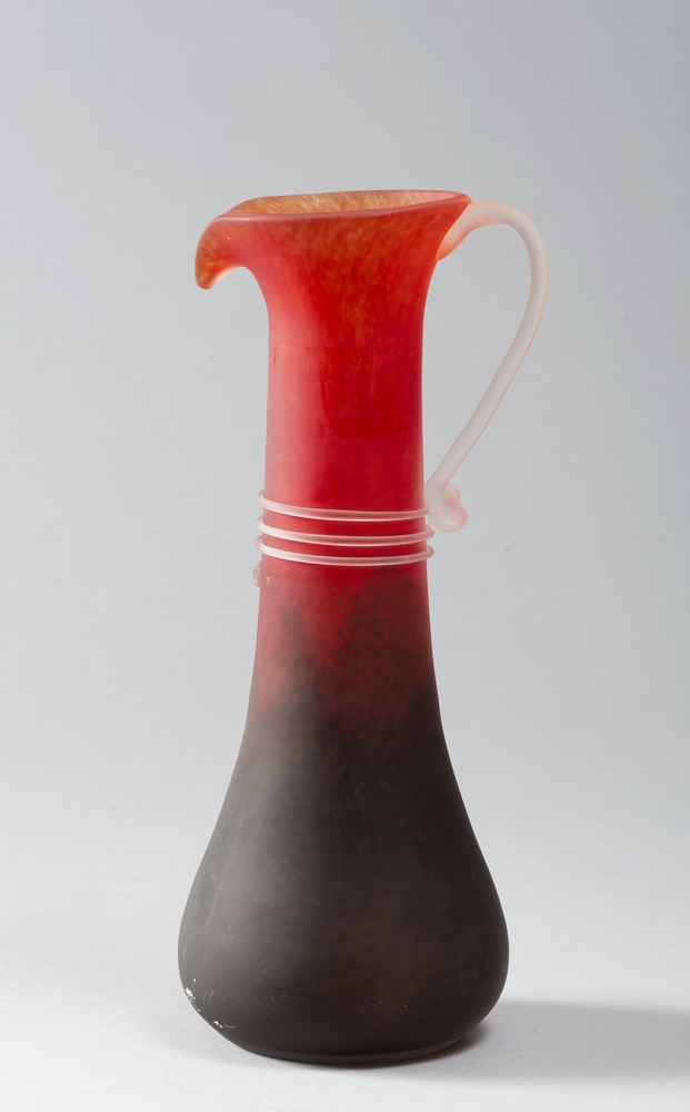 GLASS PITCHER, PROBABLY FRANCE, 80S  to orange gradient background with snake handle and the body