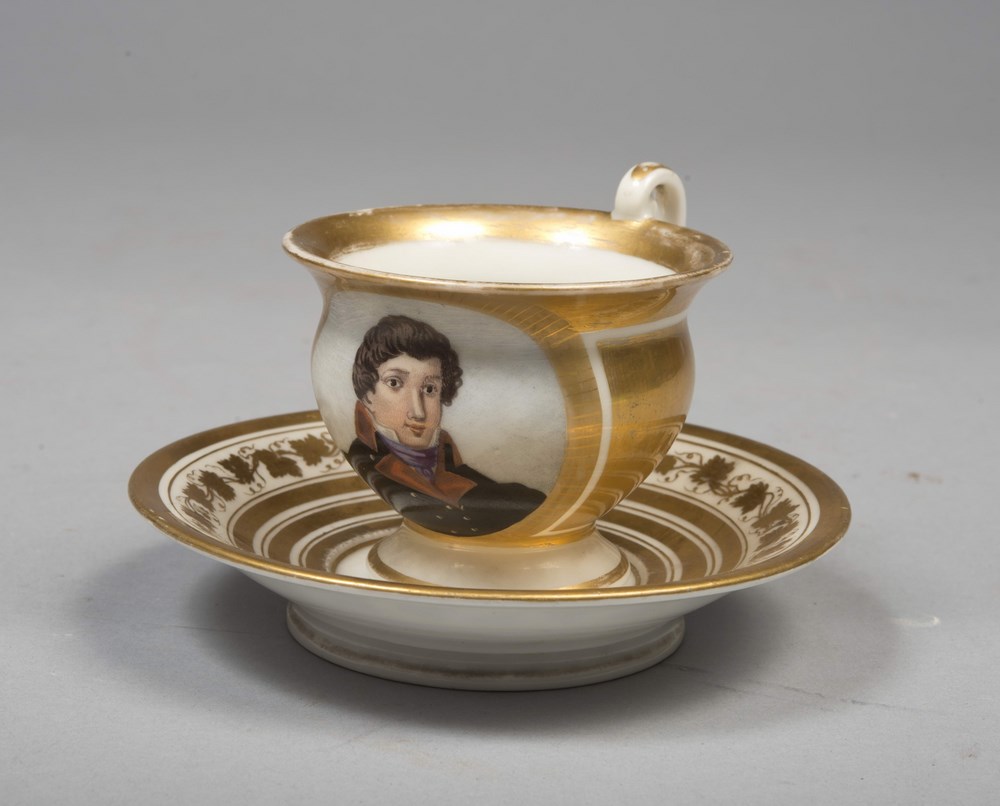 CUP AND SAUCER IN CHINA, PROBABLY NAPLES, EMPIRE PERIODgold and polychrome, with body-centered by a