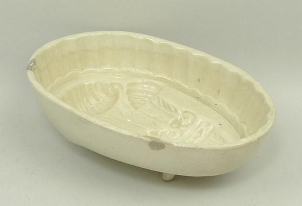 A creamware jelly mould, early 19th century, moulded with the Prince of Wales feathers, 17.5 by