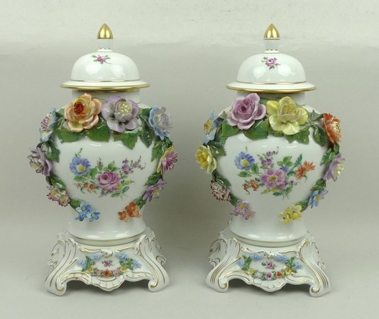 A pair of Dresden porcelain vases, covers and stands, of baluster form encrusted and painted with