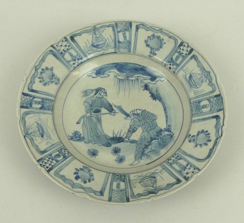 A Chinese blue and white dish painted with figures within a border or repeating reserves of boats