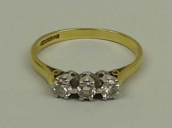 An 18ct gold, platinum and diamond three stone ring, size M, approximately 0.25ct, 2.3g.