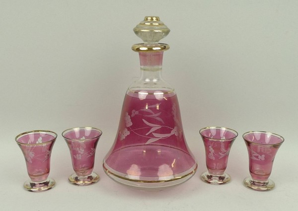 A Continental pink glass decanter and four glasses, circa 1950's, with pink resist and etched floral