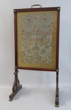 A Chinese four panel embroidery in a 19th century mahogany fire screen, panel mounted on silk,