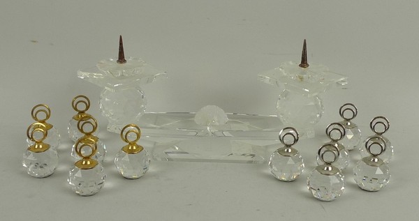 A Swarovski pricket stand, 7 by 6cm, and two boxed sets of six Swarovski name place settings, one
