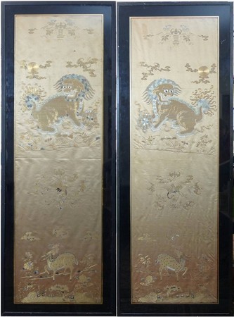 A pair of Chinese silk panels/chair back covers, 19th century, embroidered with Buddhistic lions,