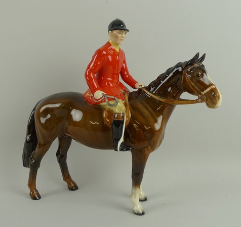 A Beswick pottery figure modelled as a huntsman in red jacket on a brown horse, 24 by 22cm.