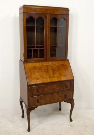 A reproduction Queen Anne style fall front bureau bookcase with glazed upper section, raised on