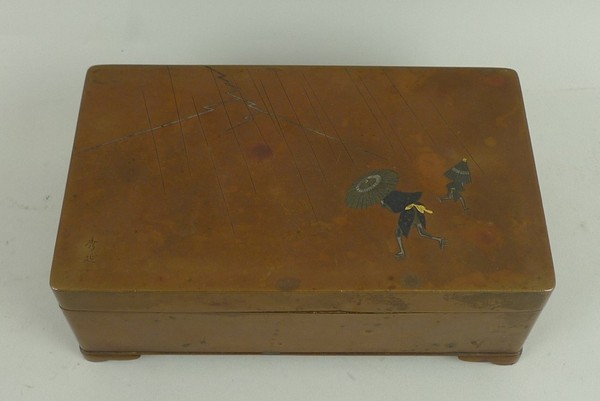 A Japanese inlaid copper cigarette box with gold and silver inlay depicting a storm with