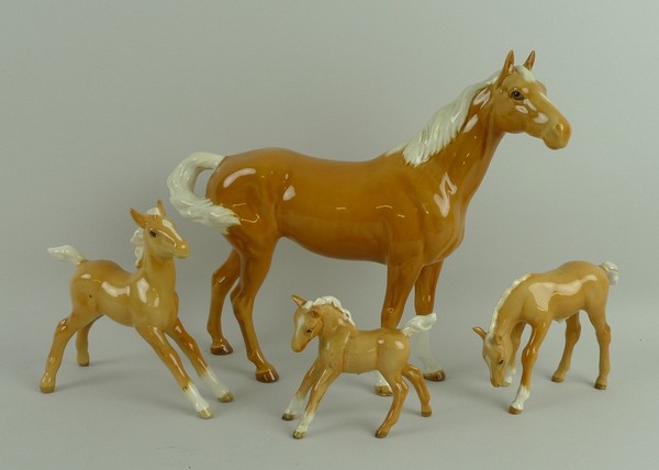 A Beswick figure of a swish tail palomino horse, no 1182, and three palomino foals, nos 996, 836 1st