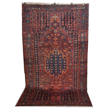 A Maslaghan rug with central medallion with lightning pattern around the edges on an elongated red