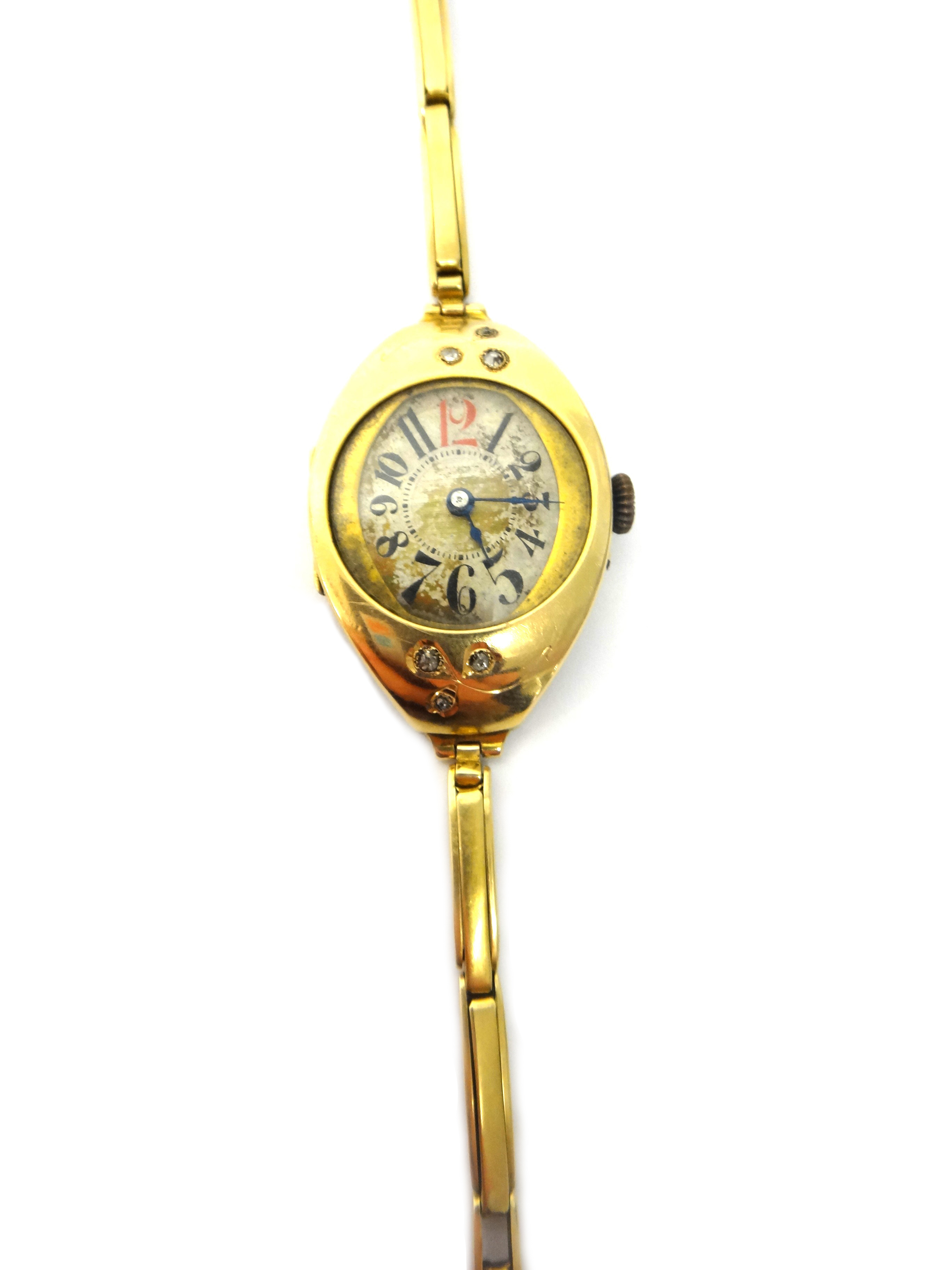 A lady's gold and diamond set curved oval cased dress wristwatch, with a circular jeweled cylinder