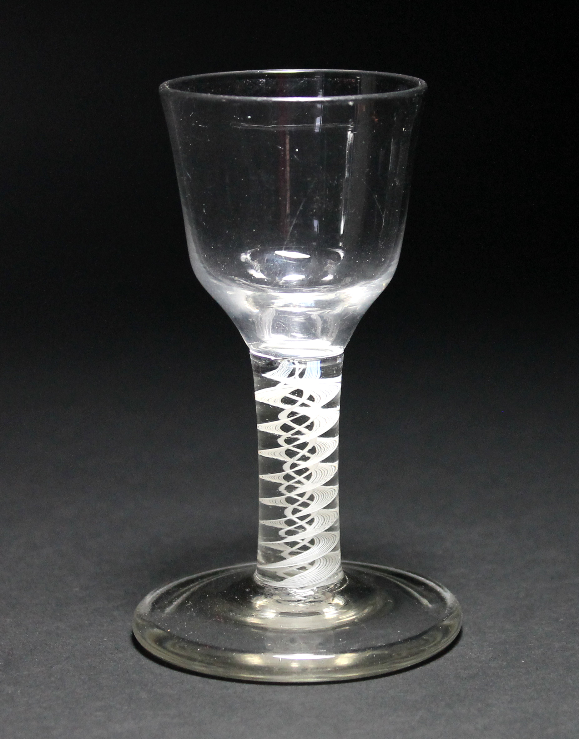 An opaque twist firing glass, circa 1765, the ogee bowl above a double series stem and thick conical