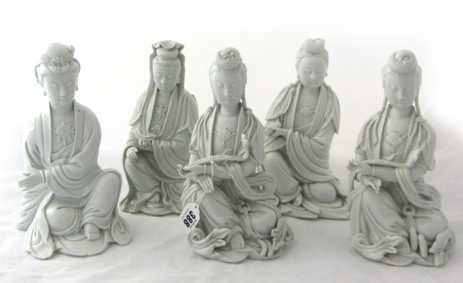 Five Chinese blanc-de-chine figures of Guanyin, late 19th/20th century, each modelled seated in long