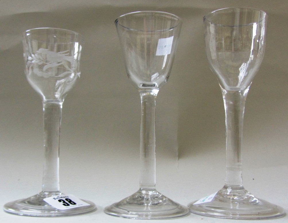 Three plain stemmed wine glasses, mid 18th century, one with ogee bowl engraved with a bird and
