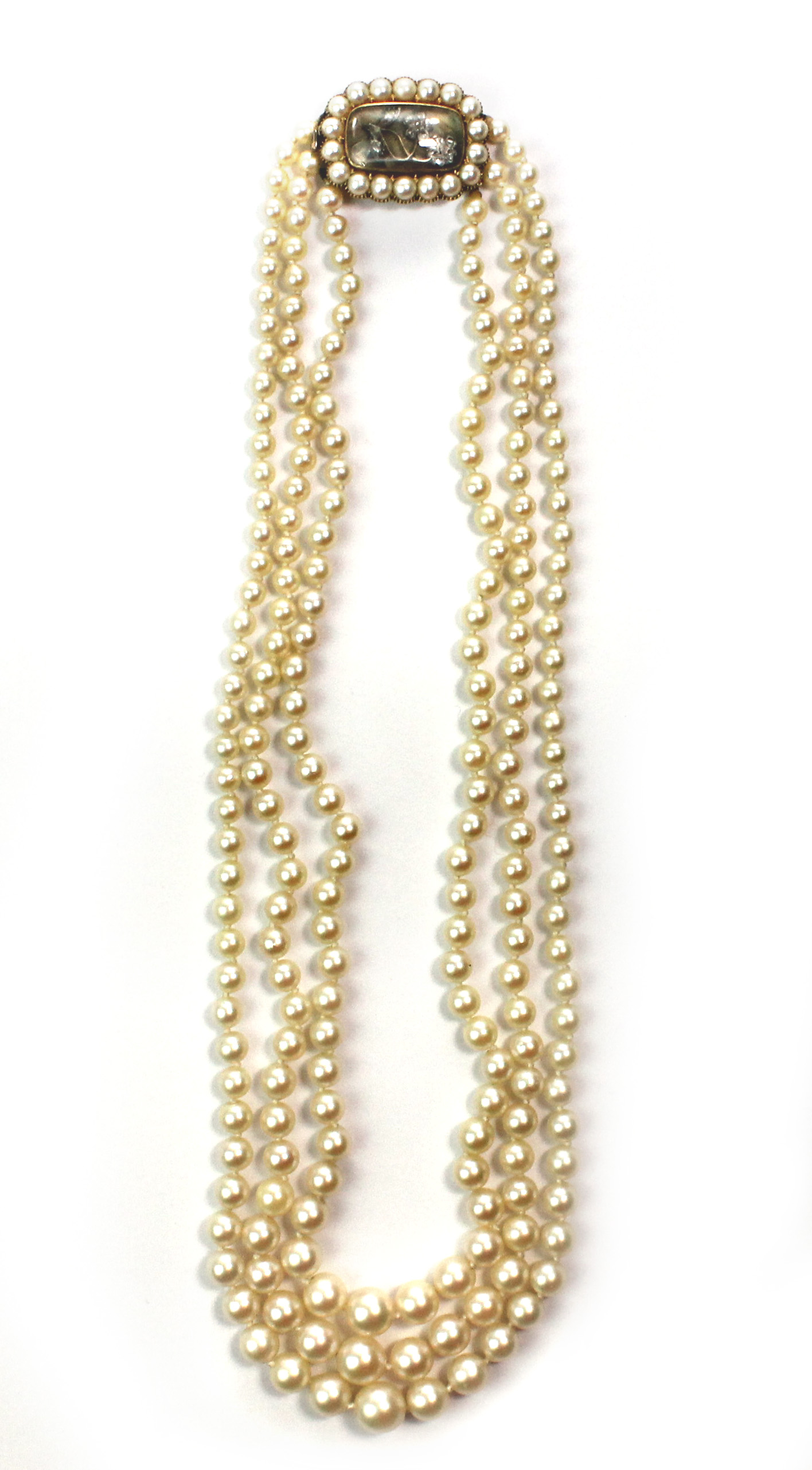 A three row necklace of cultured pearls, graduating in size to the front, on a gold, half pearl