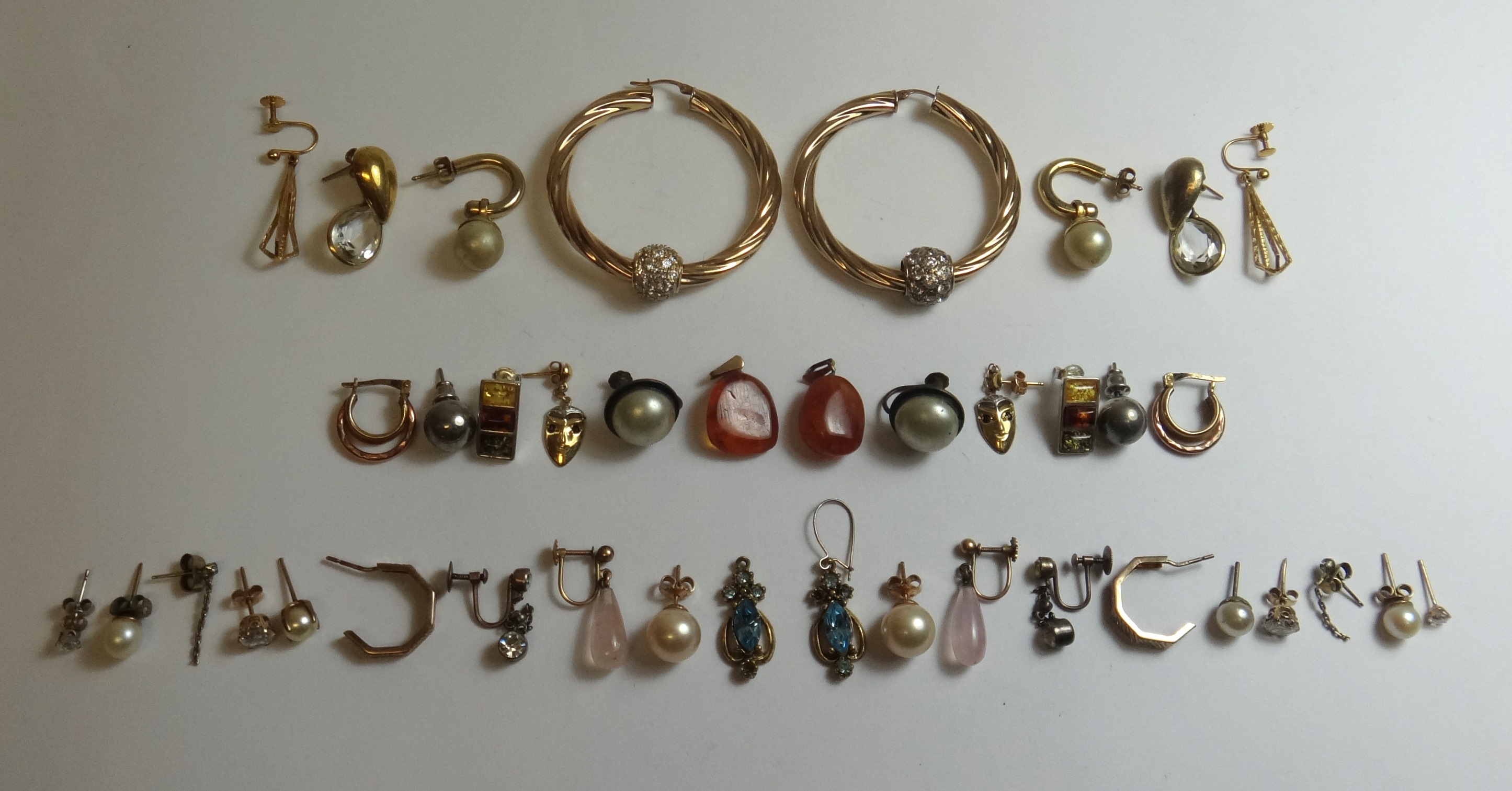 Twenty pairs of earrings, in a variety of designs.