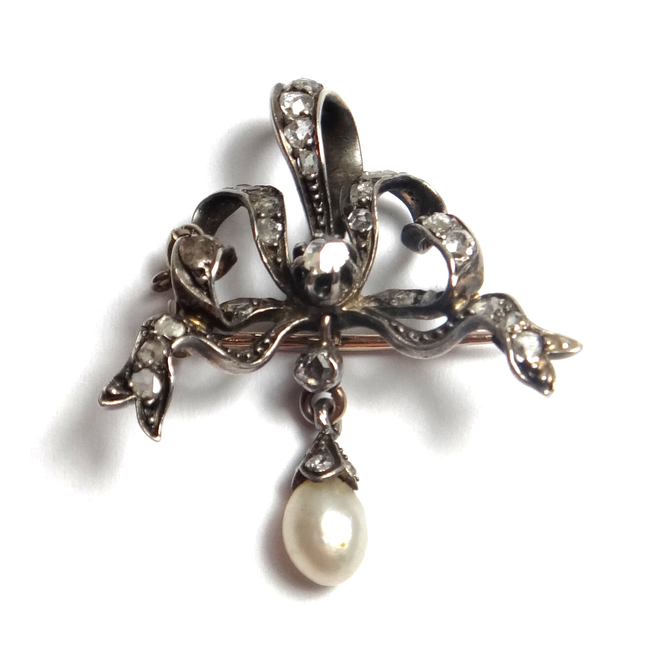 A diamond and cultured pearl set brooch, designed as a tied bow, mounted with rose cut diamonds, the