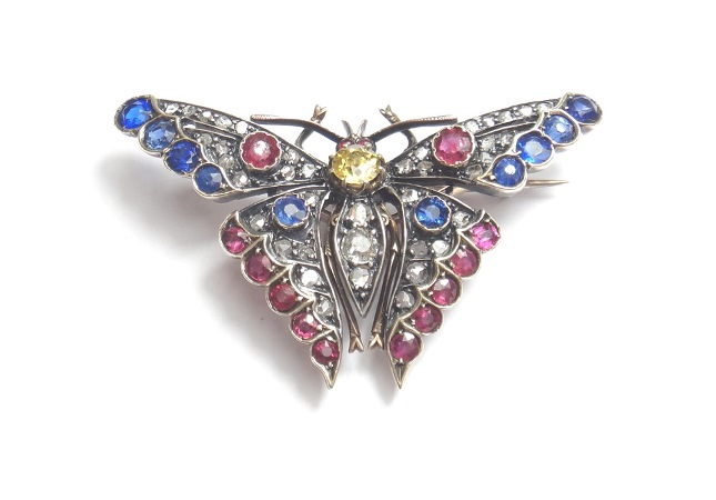 A diamond, sapphire and vary coloured gem set brooch, designed as a butterfly with outspread wings.
