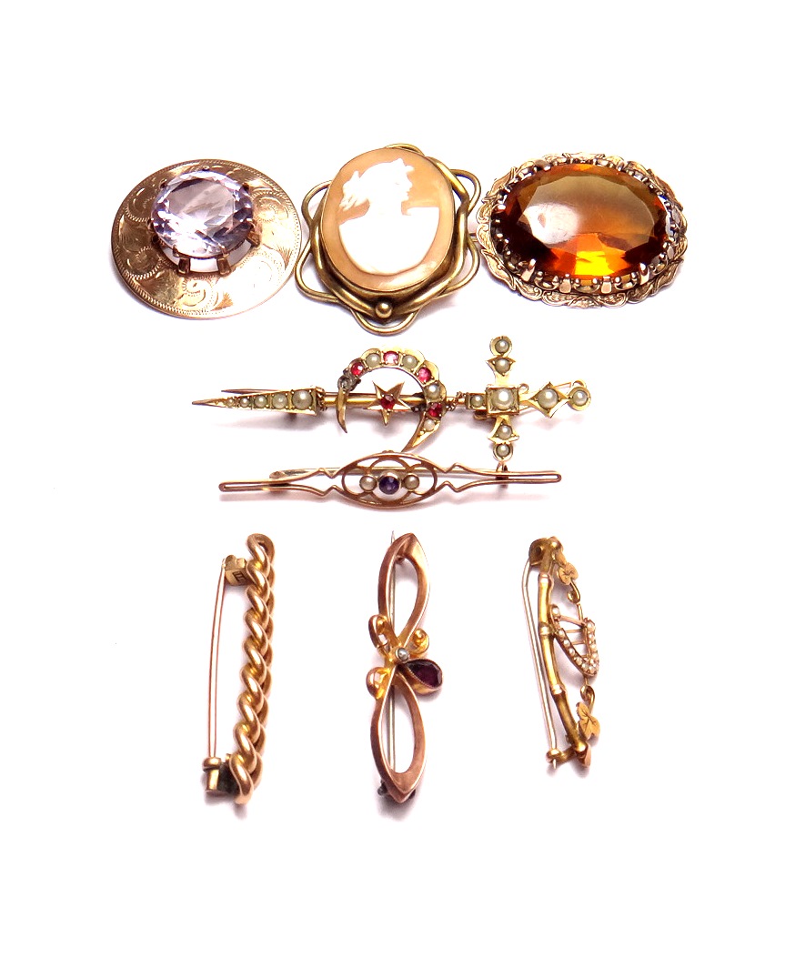 A 9ct gold circular brooch, claw set with a circular cut pale amethyst, an oval yellow paste set