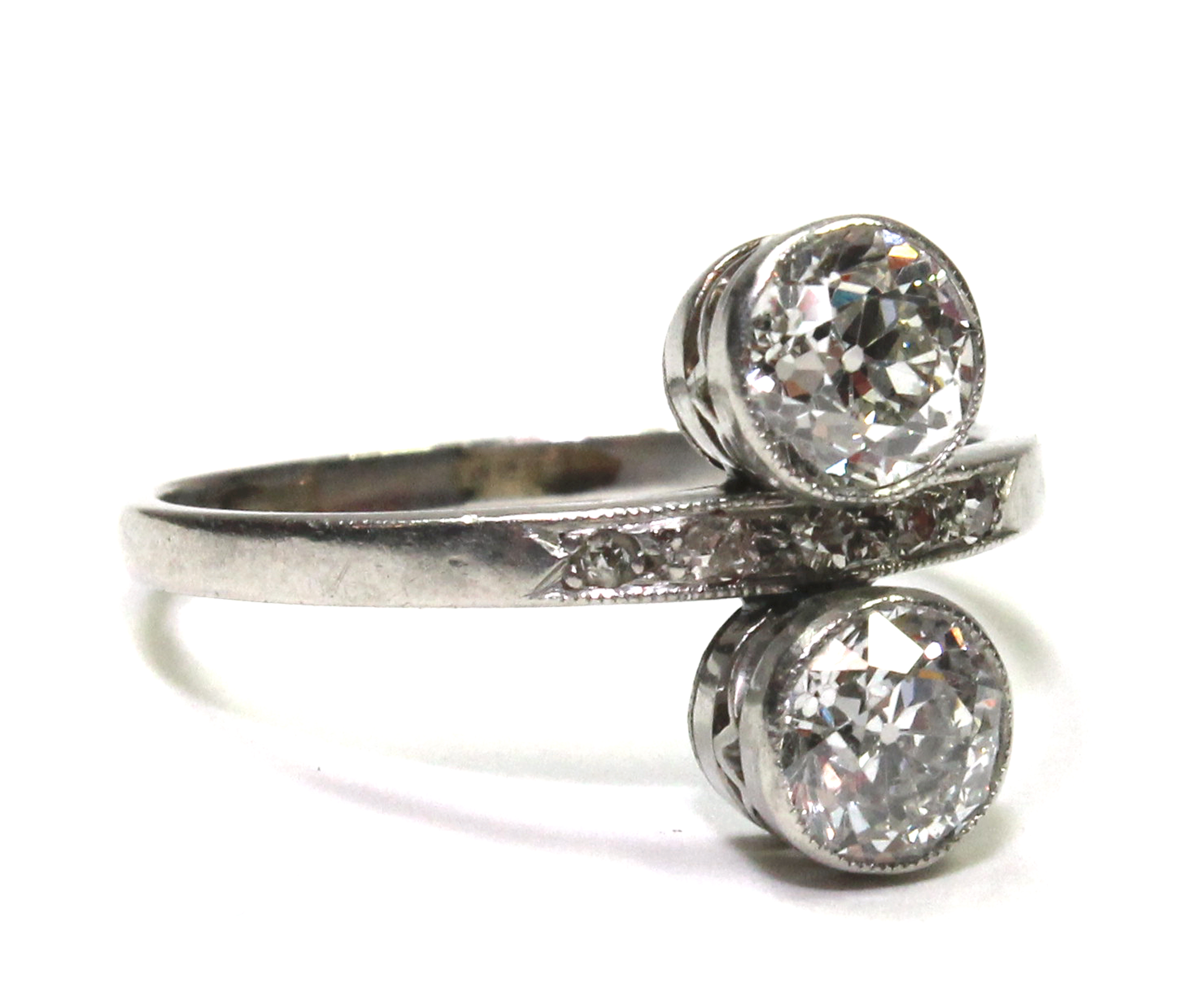 A diamond ring, collet set with the two principal cushion shaped diamonds at the centre, in an