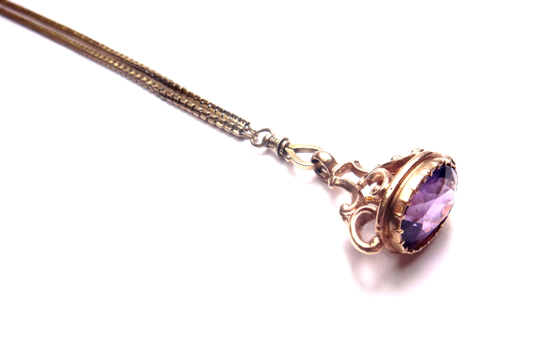 A Victorian gold long guard muff chain, the front mounted with a swivel, fitted with an amethyst set