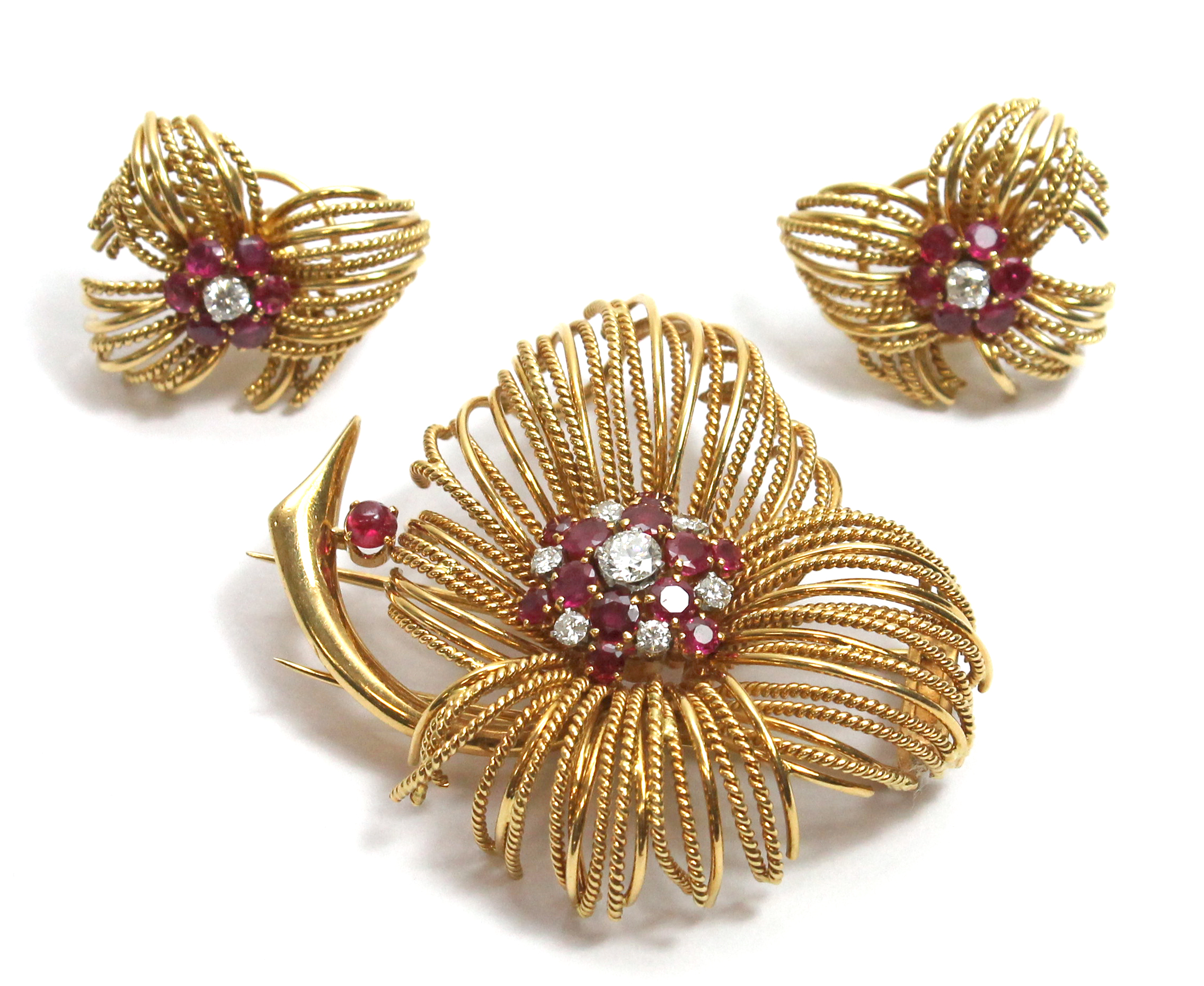 An 18ct gold, diamond and ruby set brooch, designed as a stylised flowerhead, mounted with the