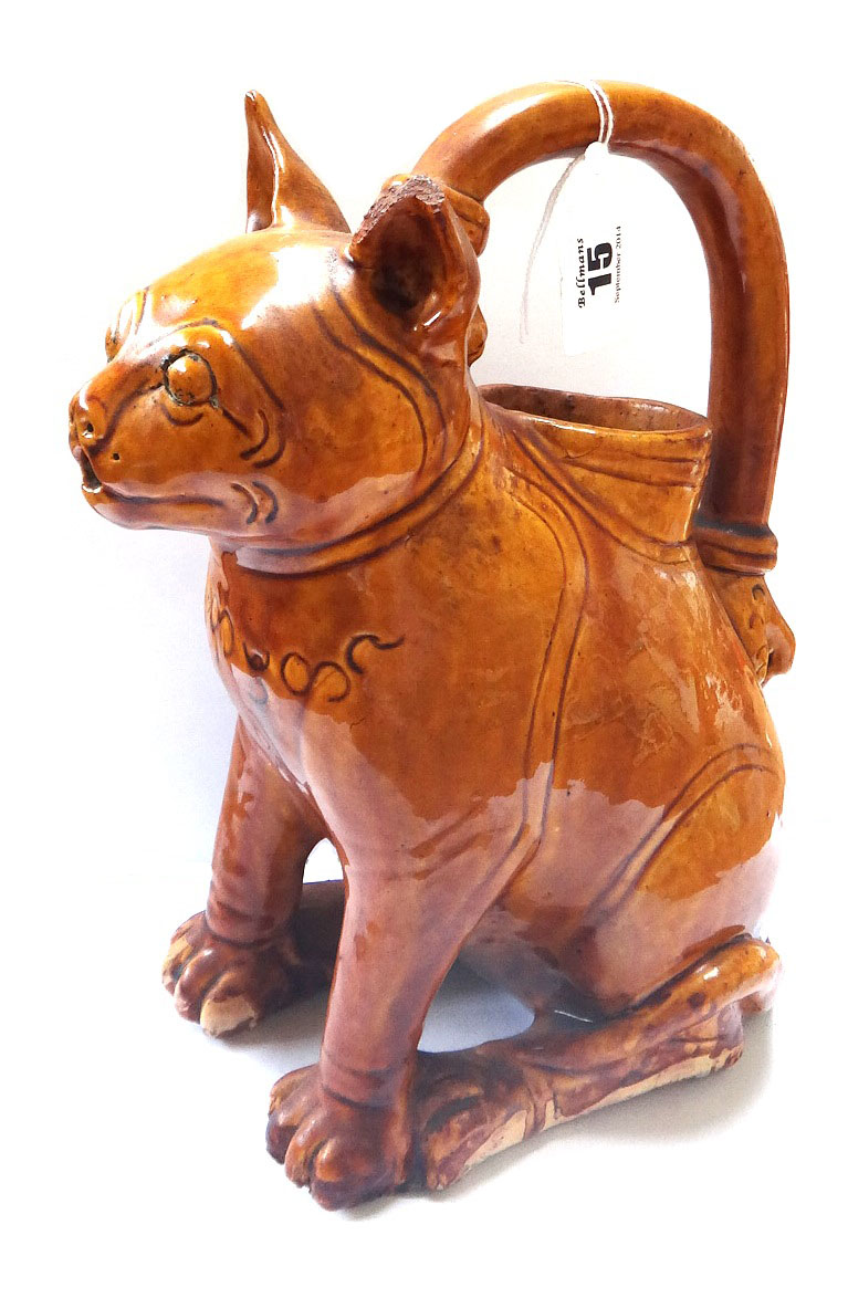 An unusual novelty pottery jug, possibly early 20th century, modelled as a seated cat with incised