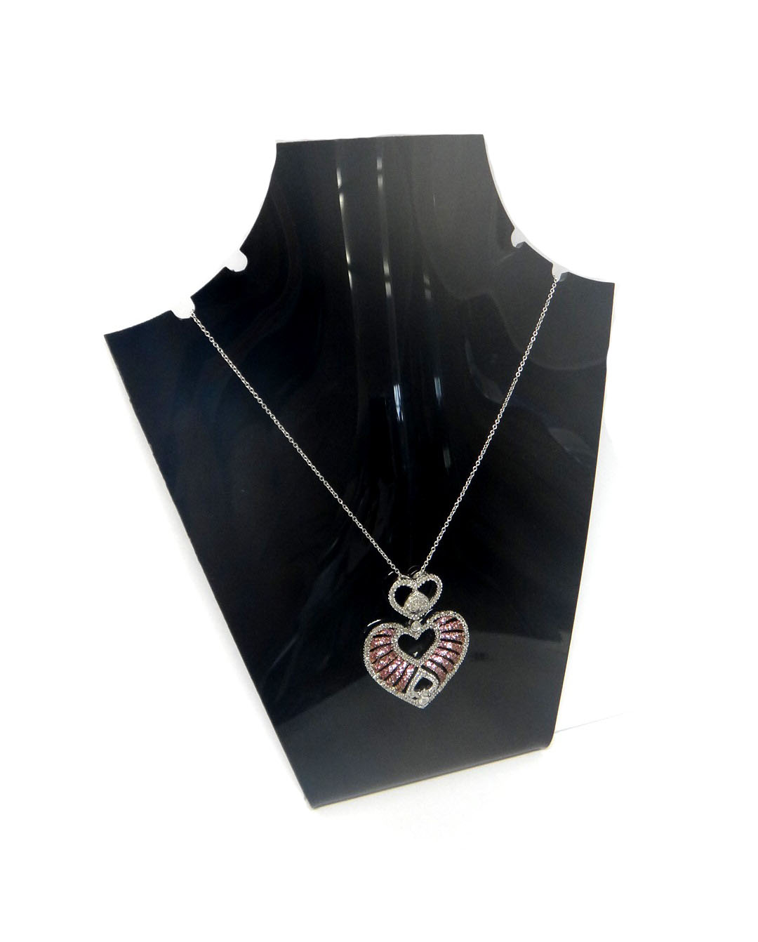 A pink sapphire and diamond set pendant, in an open heart shaped design, with further heart shaped