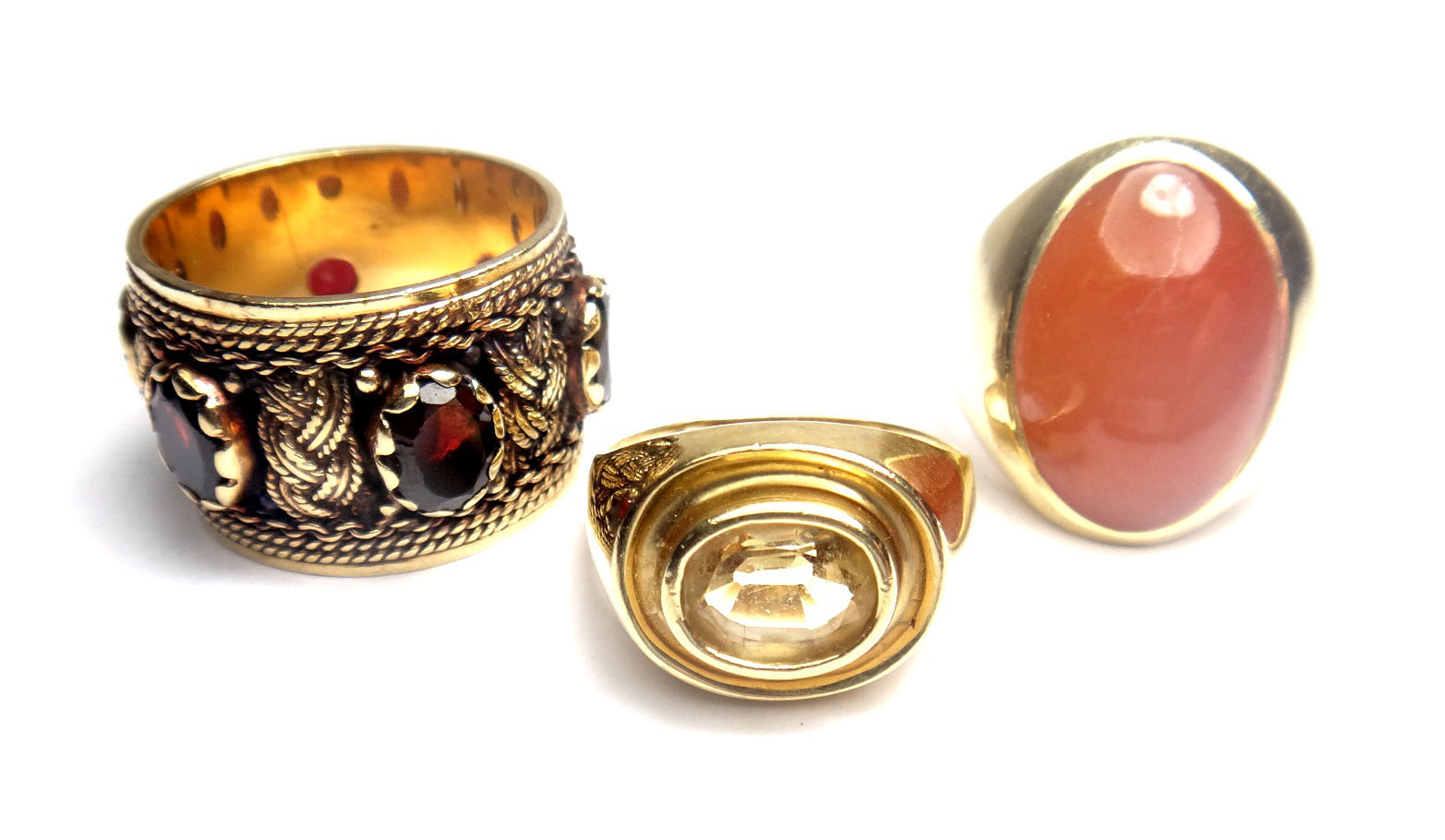 A gold and garnet set wide band ring, mounted with oval cut garnets and otherwise with interwoven