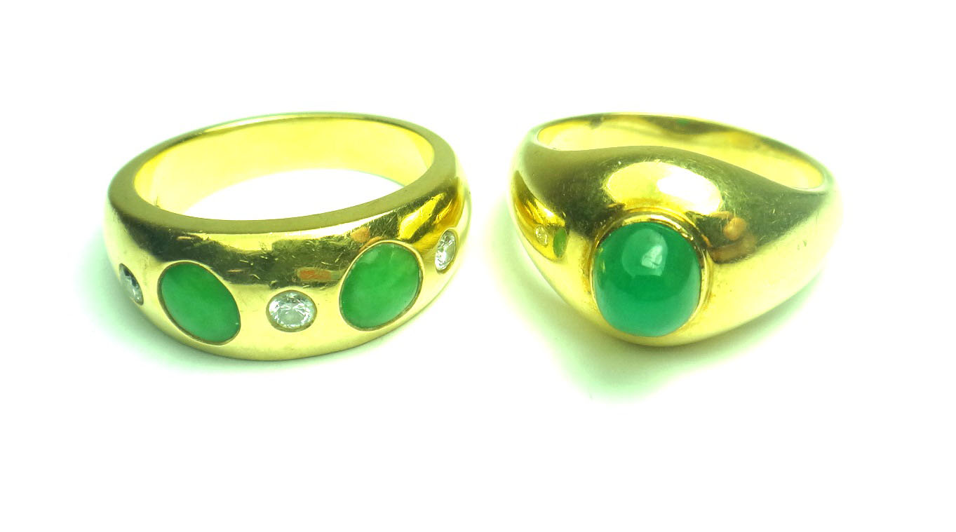 A gold, jade and diamond set five stone ring, mounted with three circular cut diamonds,